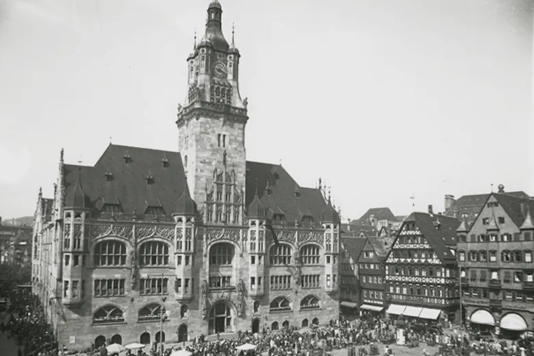 Historische Schwarz-Weiß-Aufnahme des Stuttgarter Rathauses mit Menschenmenge davor